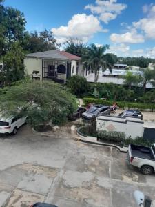 a house with cars parked in a parking lot at Se alquila apartamento amueblado en el centro de la ciudad in La Romana