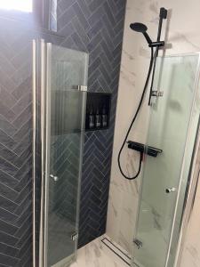 a shower with a glass door in a bathroom at Cozy & Modern Tiny House in Velserbroek  +11 photos