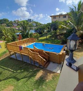 a large pool with a deck and chairs around it at Sunny Acres Villa, St.Lucia in Choc