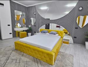 a bedroom with a yellow bed and yellow chairs at Garsoniera Craiova Centru Vechi in Craiova