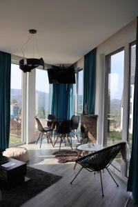 a living room with blue curtains and a table and chairs at Vila Onyx in Divčibare