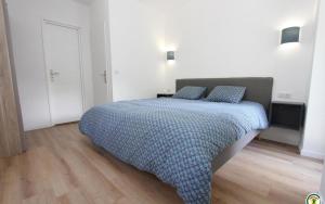 1 dormitorio con 1 cama con 2 almohadas azules en Le Moulin du Béal, en Aubres
