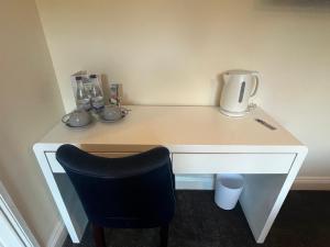 Un escritorio blanco con una silla y una jarra. en Half Moon Inn en Middlesbrough