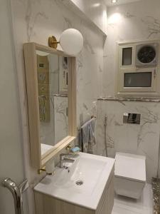 ستوديو للاقامة الفندقيةالمتميزة بالزمالك في القاهرة: حمام أبيض مع حوض ومرآة