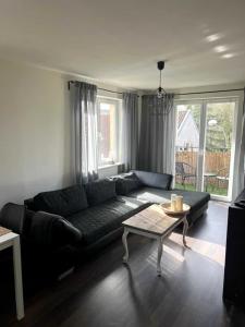 a living room with a black couch and a table at Apartament przy Browarze in Olsztyn