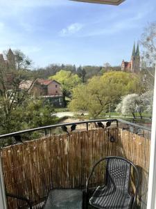 a black chair sitting on a balcony with a fence at Apartament przy Browarze in Olsztyn