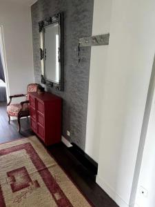 a room with a red dresser and a mirror at Apartament przy Browarze in Olsztyn