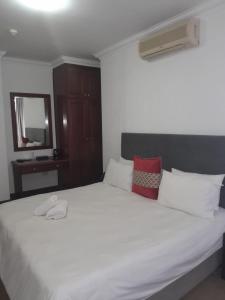 um quarto com uma grande cama branca e um espelho em Sapphire Hotel Halevy Heritage em Bloemfontein