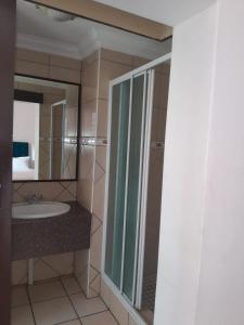 y baño con lavabo y espejo. en Sapphire Hotel Halevy Heritage, en Bloemfontein