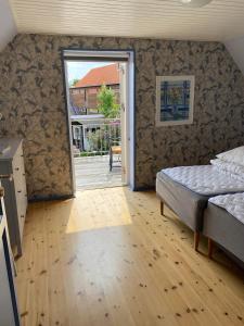 Schlafzimmer mit einem Bett und einer Tür zu einer Terrasse in der Unterkunft Skagen Bo Godt Kirkevej in Skagen