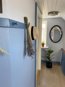 a blue door with a straw hat hanging on it at Skagen Bo Godt Kirkevej in Skagen