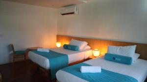 a hotel room with two beds with blue sheets at Hotel Rosario de Mar by Tequendama in Isla Grande