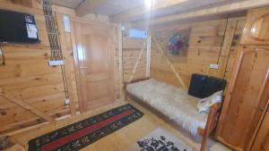 Zimmer mit einem Bett in einer Holzhütte in der Unterkunft ETNO SELO VEZIROV RANČ in Sjenica