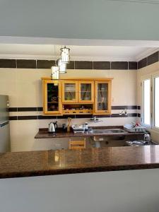 een keuken met houten kasten en een aanrechtblad bij Intimate Mediterranean Chalet in El Alamein