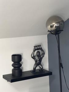 a small statue on a shelf next to a light at Le Moderne in La Chapelle-Saint-Luc