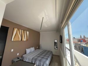 1 dormitorio con cama y ventana grande en ESPACiOS RAYON en Morelia