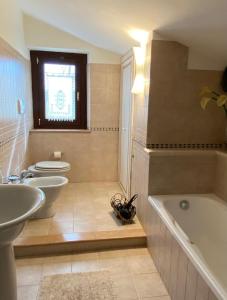 bagno con 2 servizi igienici, vasca e lavandino di Il casale di Sere a Sarnano