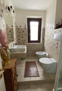 a bathroom with two sinks and a tub and a toilet at Il casale di Sere in Sarnano