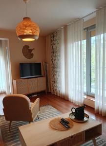ein Wohnzimmer mit einem Sofa und einem TV in der Unterkunft Apartament Boho Ustroń in Ustroń