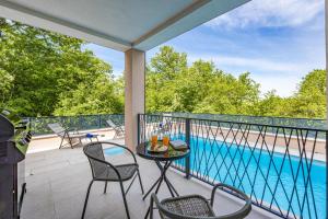 a balcony with a table and chairs and a pool at Villa IN in Nova Vas