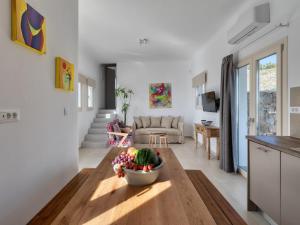 Gorgeous Mykonos Villa | 4 Bedrooms | Villa Atalanta | Private Pool & Panoramic Sea Views | BBQ | Faros في Fanari: غرفة معيشة مع وعاء من الفواكه على طاولة