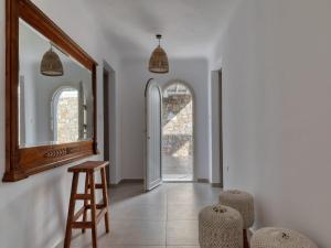 a hallway with a mirror and a stool and chairs at Gorgeous Mykonos Villa | 4 Bedrooms | Villa Atalanta | Private Pool & Panoramic Sea Views | BBQ | Faros in Fanari