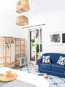 ein Wohnzimmer mit einem blauen Sofa und einem Regal in der Unterkunft Villa Michela, 2BR, 2BT, amazing patio, jacuzzi, newly renovated in Capri