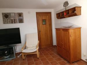ein Wohnzimmer mit einem Stuhl und einem TV in der Unterkunft Gîte Le Garny à la Baudinière in Boyer