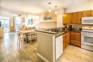 a kitchen with wooden cabinets and a dining room at Club Wyndham Ocean Boulevard in Myrtle Beach