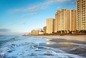 a beach with tall buildings and the ocean at Club Wyndham Ocean Boulevard in Myrtle Beach