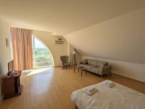 een kamer met een bed, een bank en een raam bij Hotel Tsiskari in Ianet'i
