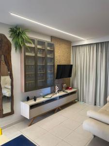 a living room with a tv and a table at EKOARA BEIRA MAR 127 in Porto De Galinhas