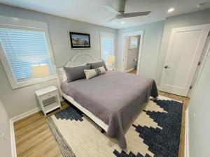 een slaapkamer met een groot bed en een tapijt bij Saltmeadow House in Surf City
