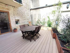 a wooden deck with a table and chairs on it at Grand appartement face au Duché d'Uzès in Uzès