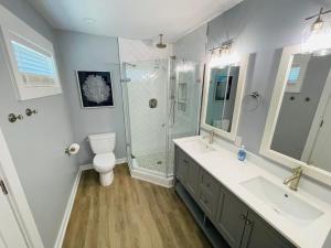 een badkamer met een douche, een toilet en een wastafel bij Saltmeadow House in Surf City