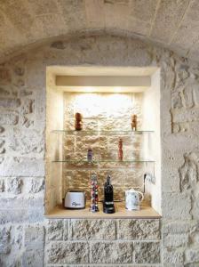 een plank in een stenen muur met een broodrooster en feiten bij Grand appartement face au Duché d'Uzès in Uzès