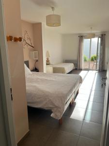 a hotel room with two beds and a balcony at Studio 1 avec piscine & vue sur la baie d'Ajaccio in Alata +9 photos