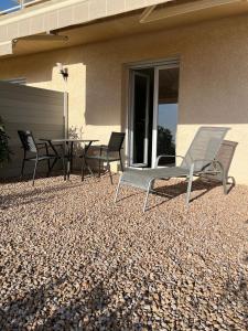 a pair of chairs and a table on a patio at Studio 1 avec piscine & vue sur la baie d'Ajaccio in Alata