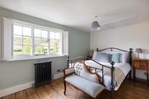 a bedroom with a bed and a chair and a window at Luxury Home, 20 Mins From Goodwood Pet Friendly! in Stoughton