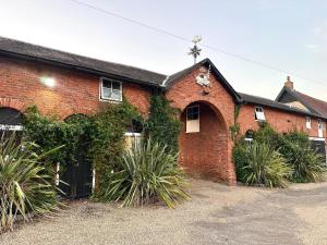 a red brick building with plants growing on it at Scole Inn Hotel in Diss