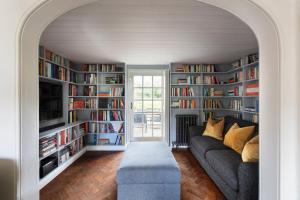 una sala de estar con sofá y estanterías de libros en Luxury Home, 20 Mins From Goodwood Pet Friendly!, en Stoughton
