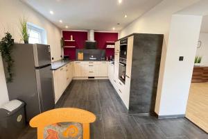 cocina con armarios blancos y paredes rojas en Shine Apartment Schwarzenfeld, en Schwarzenfeld