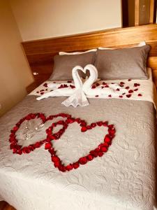 a bed with two hearts and a couple of roses at Refúgio da Montanha in Urubici