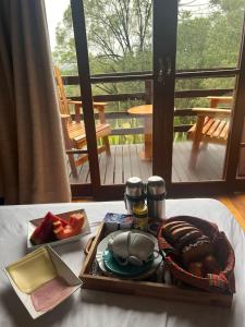 a tray of food on a table in front of a window at Refúgio da Montanha in Urubici