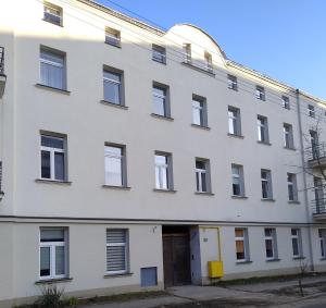 Un ancien bâtiment blanc avec un garage dans l'établissement Kolejowy Zajazd 1, à Łódź