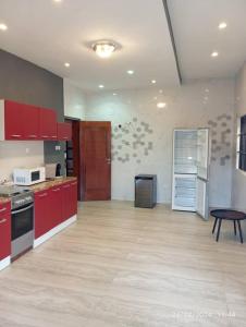 a large kitchen with red cabinets and a table at Havre de paix in Cotonou