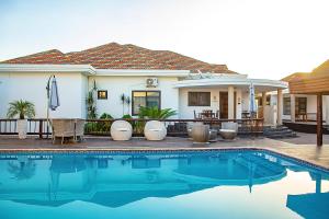 a house with a swimming pool in front of a house at Platinum Lodge Matola in Matola