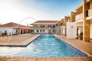 a swimming pool in front of a house at Platinum Lodge Matola in Matola