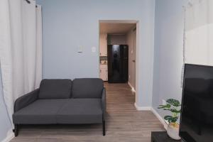 sala de estar con sofá y nevera negra en Avenir Centre Suite en Moncton