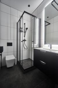 a bathroom with a shower and a toilet and a sink at Apart Hotel Acropolis in Odesa